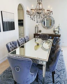 a dining room table with blue chairs and a chandelier