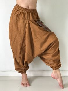 "These super soft rayon baggy unisex harem pants have the \"flow\", perfect of yoga or just a cool strolling. Comfort and character are what these pants are all about. They have the traditional sarong look & feel but a lot more practical when it comes to activity like yoga. As a bonus, they are convertible! Just pull them up and you get yourself a cute jumpsuit in a flash. Together with elastic cuff legs, you can wear them short or long. The pants have smock waist (wide bang elastic) with no Relaxed Fit Harem Pants For Meditation, Relaxed Fit Harem Yoga Pants, Yoga Harem Pants With Elastic Waistband, Baggy Parachute Pants For Yoga, Relaxed Fit Harem Bottoms For Meditation, Casual Harem Bottoms For Meditation, Meditation Harem Bottoms With Elastic Waistband, Casual Baggy Drop Crotch Yoga Pants, Baggy Brown Harem Pants With Elastic Waistband