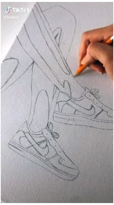 someone is drawing on paper with a pencil