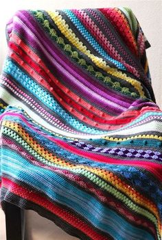 a multicolored blanket sitting on top of a chair