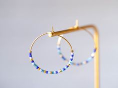 "Creole brass earrings gilded with fine gold, embellished with fine Japanese Miyuki glass beads in shades of blue and gold. Creole diameter: 2.7 cm The gilding is made by a Parisian gilder craftsman on a raw brass base. All materials used comply with European standards. Jewel delivered in gift pouch. Neat sending by followed mail https://www.instagram.com/ateliervivienne https://atelier-vivienne.com TO SEE THE ENTIRE \"CREOLES\" COLLECTION: https://www.etsy.com/fr/shop/AtelierVivienne?ref=seller French Crafts, Creole Earrings, Brass Hoop Earrings, Brass Hoops, Gift Pouch, Gold Jewellery Design, Brass Earrings, Jewelry Earrings Hoops, Raw Brass