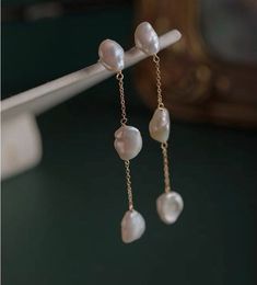 These genuine freshwater baroque pearl dangle earrings make for an elegant addition to any outfit. Classic jewelry vibe combined with the fashion-forward trend. Comfortable for daily wear, suitable for every occasion. DETAILS * 14K Gold filled * Brass ( Nickle Free) * Freshwater baroque Pearls * Lead Free and Nickel Free MEASURES Earrings Length: approx 5cm Pearl size: approx 1.1cm (The freshwater pearls are approx, We'll make sure the pearls used complement each other well) Sell as a pair PACKA Minimalist Single Baroque Pearl Earring, Dainty Baroque Pearl Dangle Earrings, Minimalist Baroque Pearl Dangle Jewelry, Minimalist Baroque Pearl Earrings In Pearl White, Minimalist Baroque Pearl Earrings For Gift, Minimalist Baroque Pearl White Pearl Earrings, Dainty Pearl Earrings With Baroque Pearls As A Gift, Dainty Baroque Pearl Earrings As A Gift, Dainty Baroque Pearl Earrings Gift