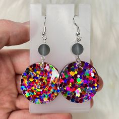 These handmade resin statement earrings add a playful touch to any outfit with their vibrant color pop of pink, yellow, and purple. Each earring features a unique glass bead, making them one-of-a-kind pieces. Elevate your style with these colorful and chic earrings. Glass bead color will vary ❤️ Nickle Free  Each pair of earrings is unique and handmade. Playful Jewelry With Matching Earrings For Party, Multicolor Resin Jewelry For Party, Rainbow Round Earrings For Party, Multicolor Nickel-free Earrings For Party, Nickel-free Multicolor Earrings For Party, Nickel-free Multicolor Resin Jewelry, Playful Purple Jewelry For Party, Playful Purple Party Jewelry, Playful Multicolor Nickel-free Earrings