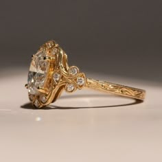 a close up view of a fancy ring with an oval cut diamond in the center