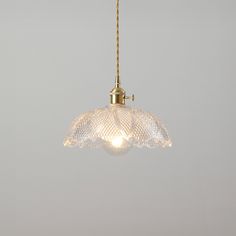 a light that is hanging from a chain on the ceiling in a room with gray walls