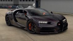 the bugatti supercar is parked in front of a building