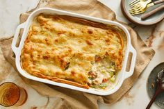 a casserole dish with meat and vegetables in it on a table next to other dishes