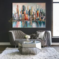 a living room with a couch, coffee table and painting on the wall above it