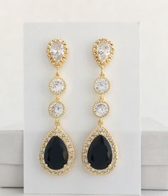 pair of black and white earrings with crystal stones in gold plated setting on display