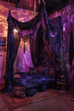 a canopy bed with purple curtains and lights hanging from it's sides in a bedroom