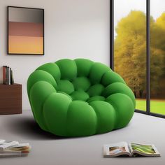 a green chair sitting on top of a white floor next to a book and window