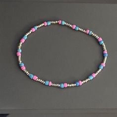 This is a dainty beaded bracelet, made of 3mm seed beads in the shades pink cosmos and Baltic blue and 2mm glass seed beads in the shade metallic silver.  The bracelet is stretchy (no clasp) with an approximate circumference of 7 inches.  Thanks for visiting my shop. Please message me if you have any questions! Adjustable Pink Beaded Bracelet With Silver Beads, Silver Heishi Beaded Bracelets With Tiny Beads, Silver Heishi Bead Bracelet With Tiny Beads, Adjustable Dainty Anklets With Colorful Beads, Dainty Adjustable Anklets With Colorful Beads, Gift Beaded Bracelet With Silver And Heishi Beads, Dainty Pink Heishi Bead Bracelets, Dainty Pink Heishi Beads Bracelet, Minimalist Pink Beaded Bracelet