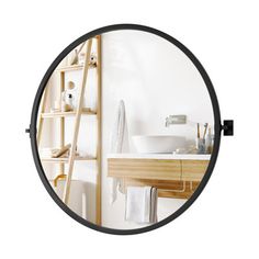 a bathroom mirror with a shelf and sink in the reflection, as well as a towel rack