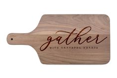 a wooden cutting board with the words gather on it