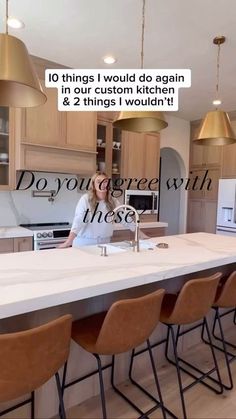 a woman standing in front of a kitchen counter with lots of chairs and an island