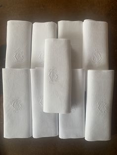 several folded white napkins sitting on top of each other in front of a wooden table