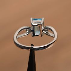 It is a Swiss blue topaz ring. The main stone is 6 mm*8 mm emerald cut.weight about 2.01 carats. The basic metal is sterling silver and plated with rhodium. To change the metal to a solid gold (white/rose) or platinum is also available, please ask for a quotation if you want. You can also go to my shop Home for more elegant rings: https://www.etsy.com/shop/godjewelry?ref=hdr_shop_menu Swiss blue topaz is November birthstone . More Swiss blue topaz rings: https://www.etsy.com/shop/godjewelry?ref= Formal Sterling Silver Topaz Ring With Rectangular Stone, Sterling Silver Topaz Ring With Rectangular Stone For Formal, Silver Emerald-cut Topaz Ring With Gemstone Accents, Fine Jewelry Blue Topaz Rectangular Rings, Silver Topaz Ring With Rectangular Blue Stone, Silver Topaz Ring With Rectangular Accent Stones, Silver Blue Topaz Ring With Rectangular Stone, Classic Blue Topaz Emerald Cut Ring, Classic Emerald Cut Blue Topaz Ring