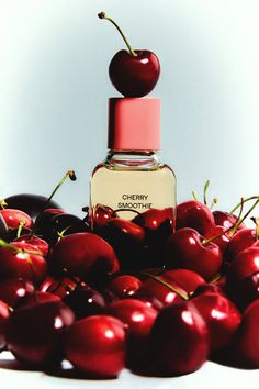 a bottle of cherry perfume surrounded by cherries