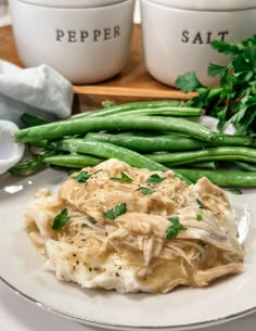 a plate with green beans and mashed potatoes next to some parsley on the side