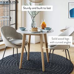 a round table with two chairs and a rug on the floor in front of it