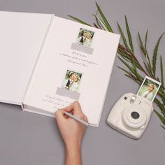 someone is holding an open photo book and taking pictures with a camera next to them