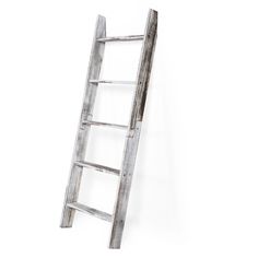 an old wooden ladder leaning up against a white wall with no one standing on it