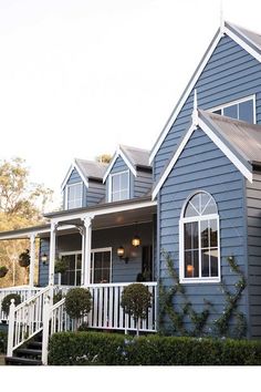 a blue house with white trim on the front porch and stairs leading up to it