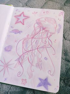 a drawing of a jellyfish and starfish on a white paper with colored pencils