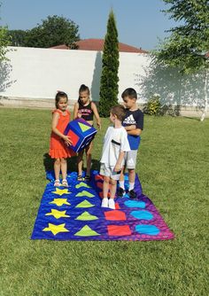 three children are playing with a kite in the yard