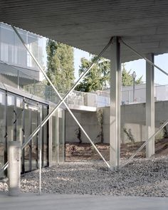 an outdoor area with glass walls and gravel