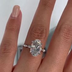 a woman's hand with a ring on it and a diamond in the middle