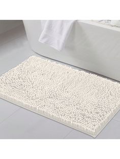 a white bath mat sitting on top of a bathroom floor