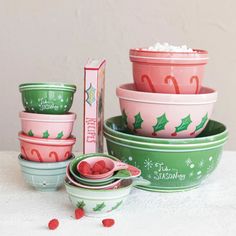 christmas themed bowls and plates with candy canes on the side, next to a box of marshmallows