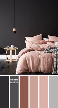 a bedroom with black walls, pink and grey bedding, two side tables and a chair