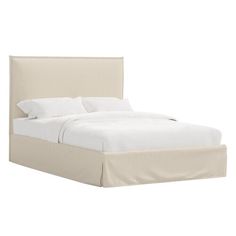 a bed with white sheets and pillows on it