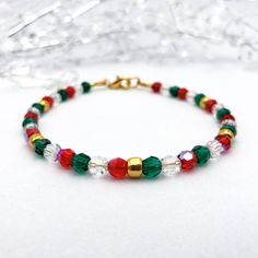 Looking for a festive Christmas beaded bracelet that will add just the right amount of sparkle to your outfit? This tasteful bracelet is the perfect choice!  The premium quality Preciosa 4mm round faceted crystal beads shimmer in shades of red, green, and clear, plus shiny gold glass beads, capturing the essence of the holiday season.  It is a perfect accessory for holiday parties, family gatherings, or as a thoughtful gift. Let this bracelet add a touch of festive magic to your ensemble! 🎄✨ Explore our collection of Christmas bracelets at https://etsy.me/48kWWWs. This bracelet is designed for style and comfort as it features a gold-plated clasp with wire guards on each end to protect the wire from wearing down over time and to prevent scratches or snags on your skin and clothing. The str Holiday Bracelets, Bracelet Elegant, Christmas Bead, Bracelet Crystal, Christmas Bracelet, Bracelet Ideas, Elegant Red, Gold Glass, Faceted Crystal