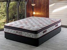 an image of a mattress in the middle of a room with wood flooring and windows