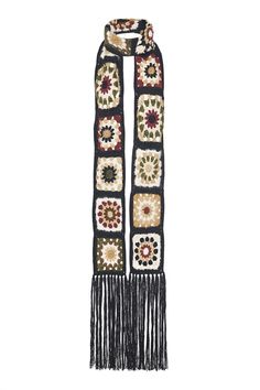 a crocheted scarf with flowers and fringes on the ends is shown in black