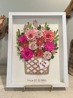 a paper flower arrangement in a white frame