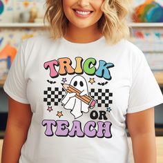 Get ready to add a playful twist to your classroom attire with our "Trick or Teach" Halloween Teacher Shirt! Featuring a charming ghost holding a pencil, this funny and cute teacher tee is perfect for educators who love to embrace the spooky spirit of Halloween. Details: - High-Quality Material: Made from soft, breathable cotton blend, ensuring comfort throughout the day. - Unique Design: Adorable ghost and pencil graphic with vibrant colors and playful text, making it a standout piece. - Versat White T-shirt For School In Fall, Holding A Pencil, Halloween Teacher Gifts, Autumn Hair Accessories, Cute And Spooky, Pencil Design, Funny Ghost, Halloween Treat Bags, Bow Shirts