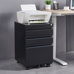 a black and white printer sitting on top of a desk