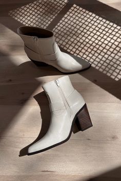 Elevate your footwear collection with the Jackson White Ankle Boots. Featuring pristine white uppers, these boots exude modern sophistication and versatility. The brown block heels provide a stylish contrast and ensure all-day comfort and stability. With convenient inner zippers, slipping them on and off is a breeze, while the outer strap details add a touch of edgy flair. The pointed toes enhance the sleek design, making these boots perfect for any occasion. The Jackson White Ankle Boots seamle White Mid-calf Boots With Stacked Heel For Fall, Trendy White Moto Boots For Fall, White Trendy Moto Boots For Fall, White Trendy High Ankle Moto Boots, White Ankle Moto Boots For Spring, White Block Heel Mid-calf Boots For Winter, Chic White Square Toe Mid-calf Boots, Chic White Mid-calf Boots With Square Toe, White Boots With Stacked Heel For Fall