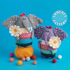 two crocheted elephants sitting next to each other on top of balls of yarn