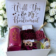 a bridesmaid gift box filled with wine, flowers and wedding rings for her