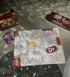 a sign that is on top of a table next to some chocolates and candy bars