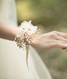 the bride is holding her wedding bouquet in her hand and she is wearing a ring on her finger