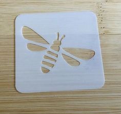 a wooden coaster with a cut out of a bee on it