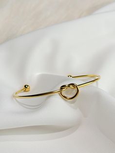 Elevate your wrist with our exquisite gold heart bangle, a symbol of timeless elegance and heartfelt sentiment. Crafted from lustrous gold-plated stainless steel, this bangle boasts durability and a luxurious shine that radiates sophistication.  The delicate heart charm adds a touch of romance, making it a perfect gift to express love and appreciation. Whether worn alone as a statement piece or stacked with other favorites, this bangle effortlessly transitions from day to night, enhancing any en Elegant Gold Heart-shaped Bangle, Valentine's Day Dainty Bangle Bracelets, Gold Metal Bracelets For Valentine's Day, Elegant Metal Heart Bangle Bracelet, Gift Bangle Heart Bracelet With Jubilee Detail, Valentine's Day Anniversary Bangle Bracelets, Valentine's Day Anniversary Bangle Bracelet, Metal Round Bracelets For Valentine's Day, Minimalist Bangle Jewelry For Valentine's Day