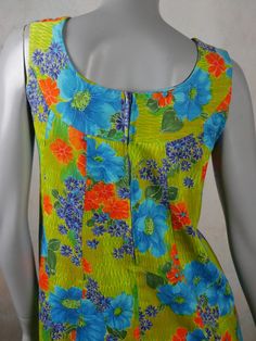 This 1970s vintage Hawaiian dress has a stunning floral pattern in blue, orange, and yellow on a green background. The sleeveless cotton summer dress has a slight scoop neckline, a relaxed-fit waistline, inverted pleats on both sides of the front, an inner back-tie so that you can fit the dress to be show your form. An 11-inch (27.94cm)zipper in the back makes dressing an ease. Size 8 US, 12 UK Bust = 36 inches (91cm) Waist = 37 inches (93.98cm), with inner tie-back if you want a more fitted look Hips = 42 inches (106.68cm) Dress Length = 35 inches (88.9cm)  Brand label: Noelani Casuals (Made in Hawaii) Material: Cotton Condition: Excellent (Professionally Cleaned ... soft and supple, with no stains, tears, wear spots, or weaknesses in the seams)   --- DESCRIPTION ASSURANCE --- I want you Hawaiian Vintage, Vintage Hawaiian Dress, Cotton Summer Dress, Vintage Tropical, Cotton Dress Summer, Hawaiian Dress, Brand Label, Vintage Hawaiian, Sleeveless Floral Dress