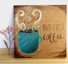 a wooden sign that says, but first coffee with a cup of hot chocolate in it